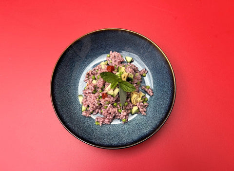 Reissalat mit rosa Reis und Garnitur angerichtet